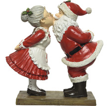 Dekorative Weihnachtsmann- und Weihnachtsfrau-Figur beim Küssen auf einem Sockel