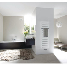 Helles Badezimmer mit Badewanne, Waschbecken, Heizkörper und Teppich