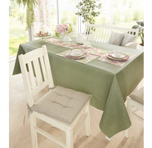 Gedeckter Esstisch mit grüner Tischdecke, Tischläufer mit Blumenmuster und weißem Geschirr.