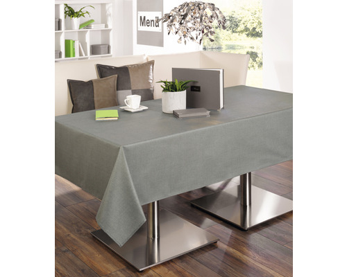 Esstisch mit grauer Tischdecke, dekoriert mit Pflanzen und Geschirr.