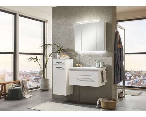 Modernes Badezimmer mit weißem Waschtischunterschrank, Spiegelschrank und Hochschrank vor Betonwand