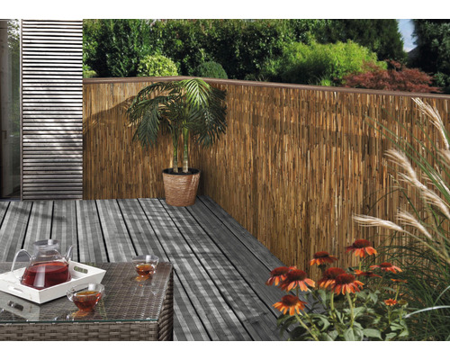 Terrasse mit Bambuszaun, Tisch, Getränken und Bepflanzung