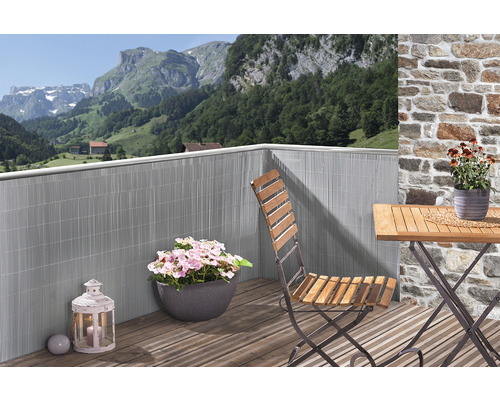 Balkonszene mit Sichtschutzmatte, Tisch, Stuhl und Pflanzen