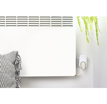 Weißer Heizkörper mit Stecker und Kissen