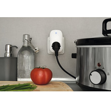 Szene einer Küchenarbeitsplatte mit einer intelligenten Steckdose, einem Slow Cooker und Küchenutensilien