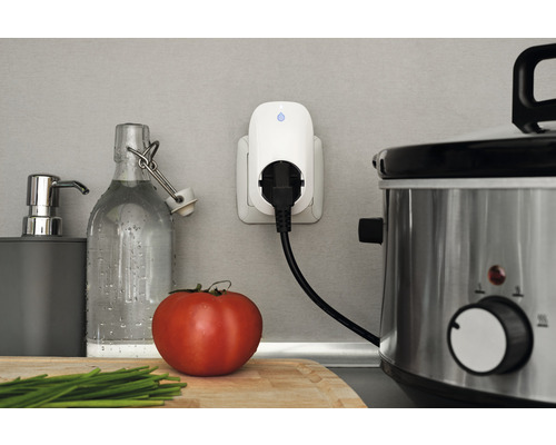 Szene einer Küchenarbeitsplatte mit einer intelligenten Steckdose, einem Slow Cooker und Küchenutensilien