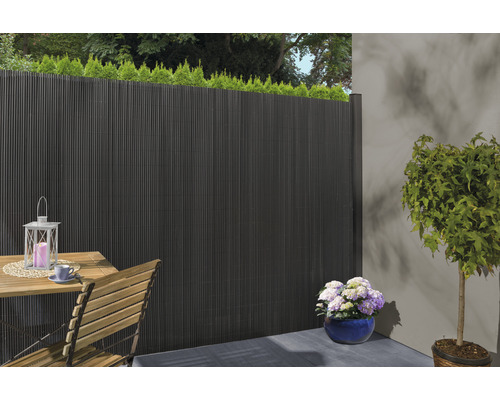 Terrassenszene mit Sichtschutzzaun, Tisch, Stuhl und Pflanzen