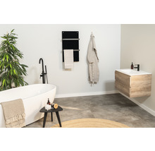 Modernes Badezimmer mit freistehender Badewanne, Waschtisch, Handtuchwärmer und Dekorationen