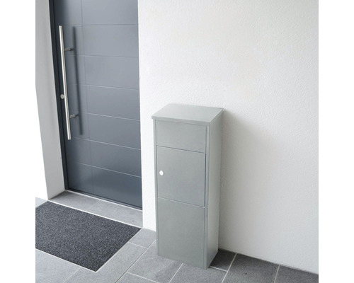 Freistehender Briefkasten aus Metall neben einer Haustür