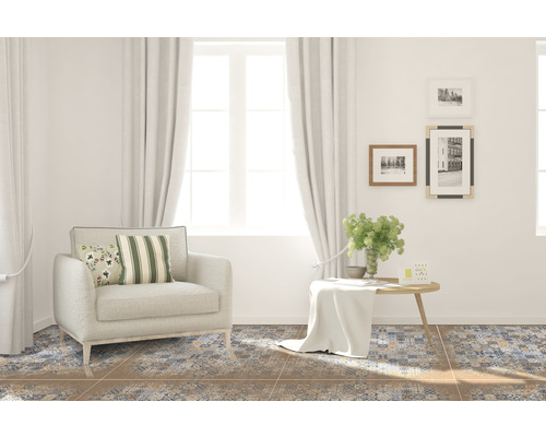 Wohnzimmer mit Sessel, Tisch und gemusterten Bodenfliesen für eine wohnliche Atmosphäre.