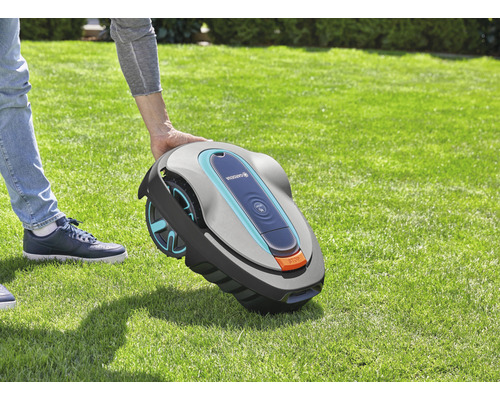 Person hält einen Gardena Mähroboter im Garten.