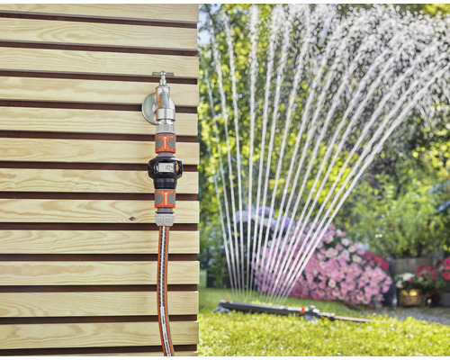 Gartenszene mit Wasserhahn, Gardena Wasserzähler und Rasensprenger