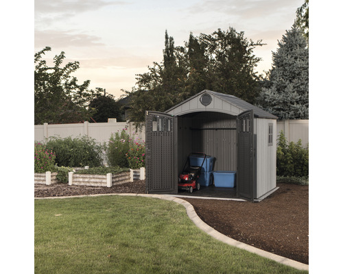 Gartenschuppen mit geöffneten Türen, Rasenmäher und Aufbewahrungsboxen im Inneren.