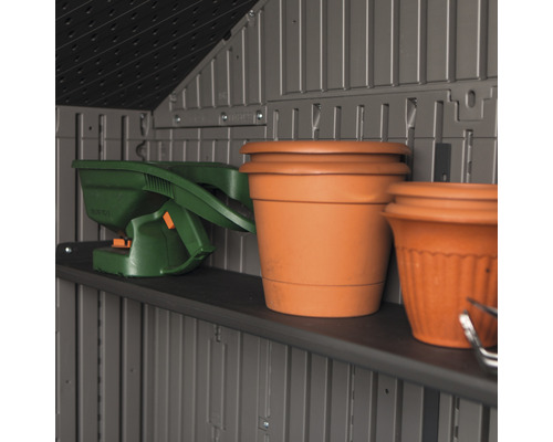 Regal in einem Geräteschuppen mit Gartengeräten und Blumentöpfen.