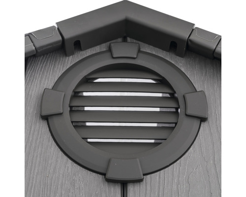 Detailansicht eines Gartenhauses mit rundem Fenster und Lüftungsgittern