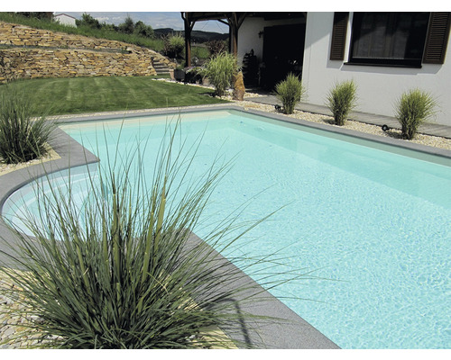 Schwimmbad im Garten mit Pflanzen und Steinmauer