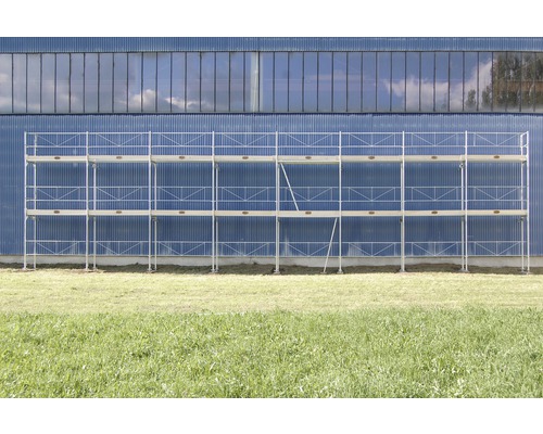 Gerüst vor einer Fassade auf einer Wiese