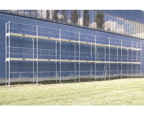 EKRO Systemgerüst für Fassaden mit Fertigbelag für Fassaden - verzinkt 120m² Aluminium Baugerüst mit drei Ebenen vor einer blauen Wand