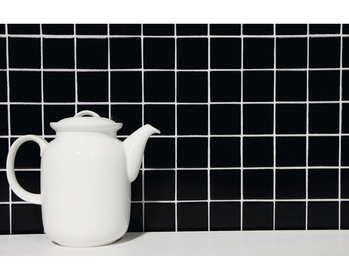 Teekanne aus Keramik vor quadratischem Fliesenmuster