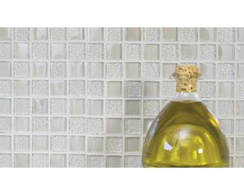 Glasmosaikfliesen mit einer Flasche Öl im Vordergrund