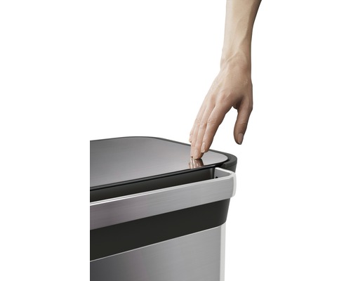 Ein Mülleimer wird mit der Hand geöffnet.