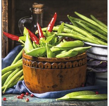 Arrangement mit grünen Bohnen, Erbsenschoten und roten Chilischoten in einer Holzschale