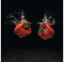 Zwei rote Paprika fallen ins Wasser