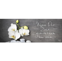 Dekoration mit Orchideenblüten, Steinen und dem Spruch ''Nimm Dir Zeit glücklich zu sein''.