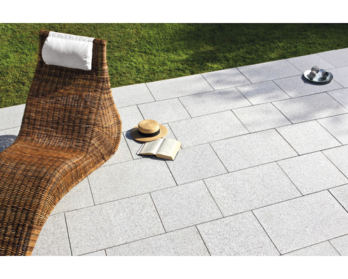 Terrasse mit Steinplatten, Liegestuhl und Accessoires