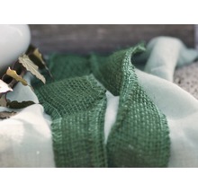 Dekoratives Arrangement mit grünem Textilband und Stoff