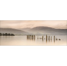 Landschaft mit See, Bergen und alten Holzpfosten im Wasser