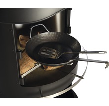 Detailansicht eines Grillgeräts mit Holz, Bratpfanne und Pfannenwender