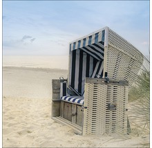 Strandkorb aus Rattan mit gestreiftem Stoffbezug am Strand