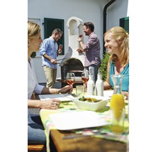 Gruppe von Personen beim Grillen im Garten mit einem gemauerten Grill und Gartentisch