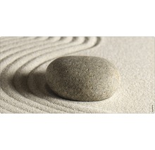 Dekorativer Stein auf Sand mit Wellenmuster