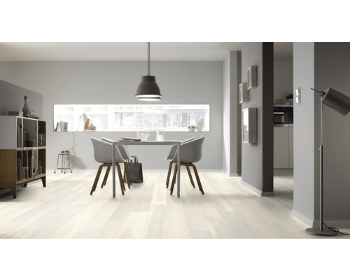 Heller Wohnraum mit Holzboden, Esstisch und Stühlen.