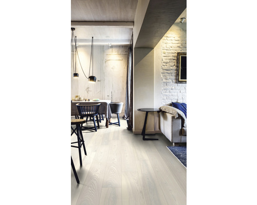 Heller Wohnraum mit Esstisch, Stühlen, Sofa und Holzboden