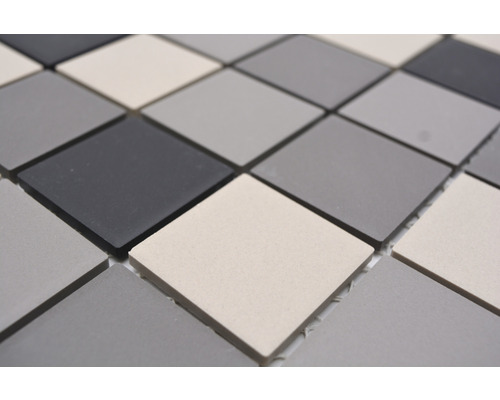Mosaikfliese mit quadratischen Elementen in unterschiedlichen Grautönen.