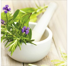 Mörser mit frischen Kräutern und Lavendelblüten auf einem Holztisch