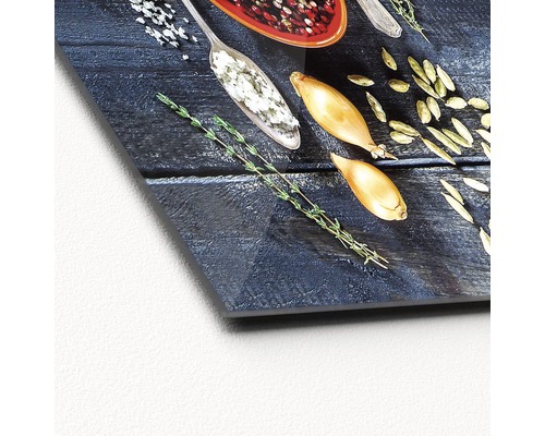Dekoratives Küchenbild mit Löffeln, Gewürzen, Schalotten und Kräutern auf Holzgrund