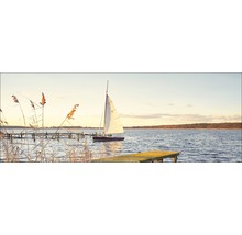 Segelboot auf einem See mit Stegen und Schilf