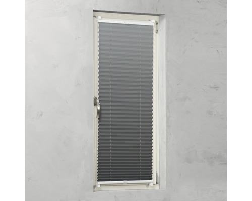 Graues Plissee-Rollo am Fenster zur Lichtregulierung