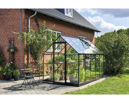 Gewächshaus im Garten mit Pflanzen und Sitzgruppe