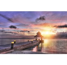 Holzsteg mit Pavillon und Beleuchtung am Meer bei Sonnenuntergang