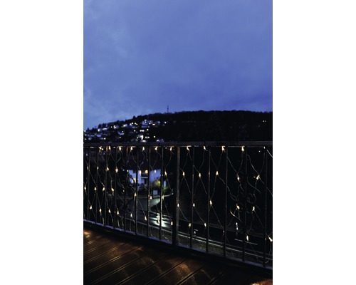 Lichtervorhang Lichternetz außen und innen Konstsmide Micro LED Lichterkettennetz 2 x 1 m 160 LEDs Lichterfarbe warmweiß transparentes Kabel Balkon mit Lichterkette und Blick auf eine abendliche Stadt.