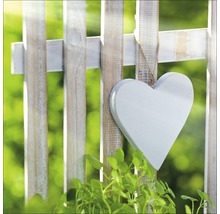 Dekoratives Holzherz hängt an einem Gartenzaun