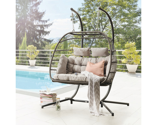 Hängesessel mit Korb und Gestell sowie Kissen auf einer Terrasse mit Pool