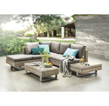 Terrasse mit Rattansitzgruppe, bestehend aus Ecksofa und Couchtischen mit Glasplatte.