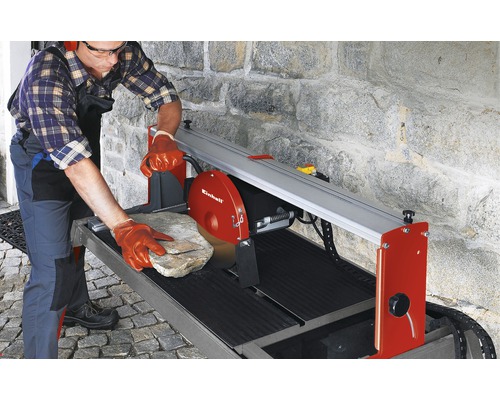 Ein Mann schneidet einen Stein mit einer Steintrennmaschine von Einhell.