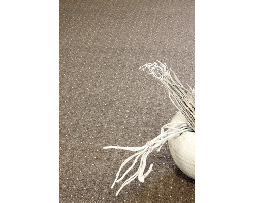 Dekorative Zweige in einer weißen Vase auf einem Teppich